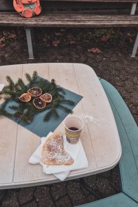 Ein Tisch mit Weihnachtslichem Schmuck, Waffeln und Punsch.