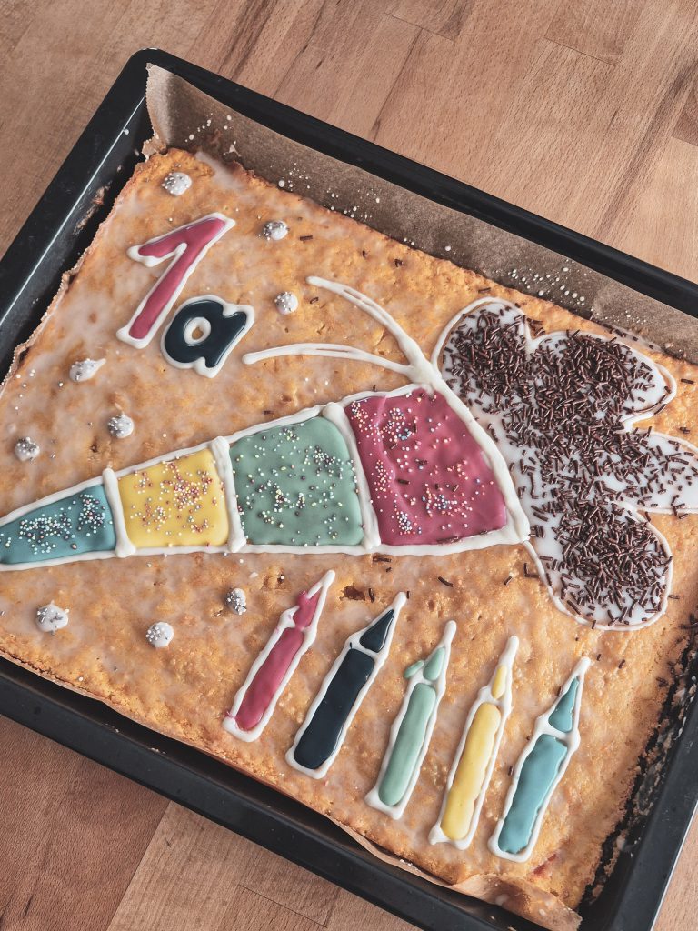 Kuchen mit einer Schultüte, Stiften und der Klasse